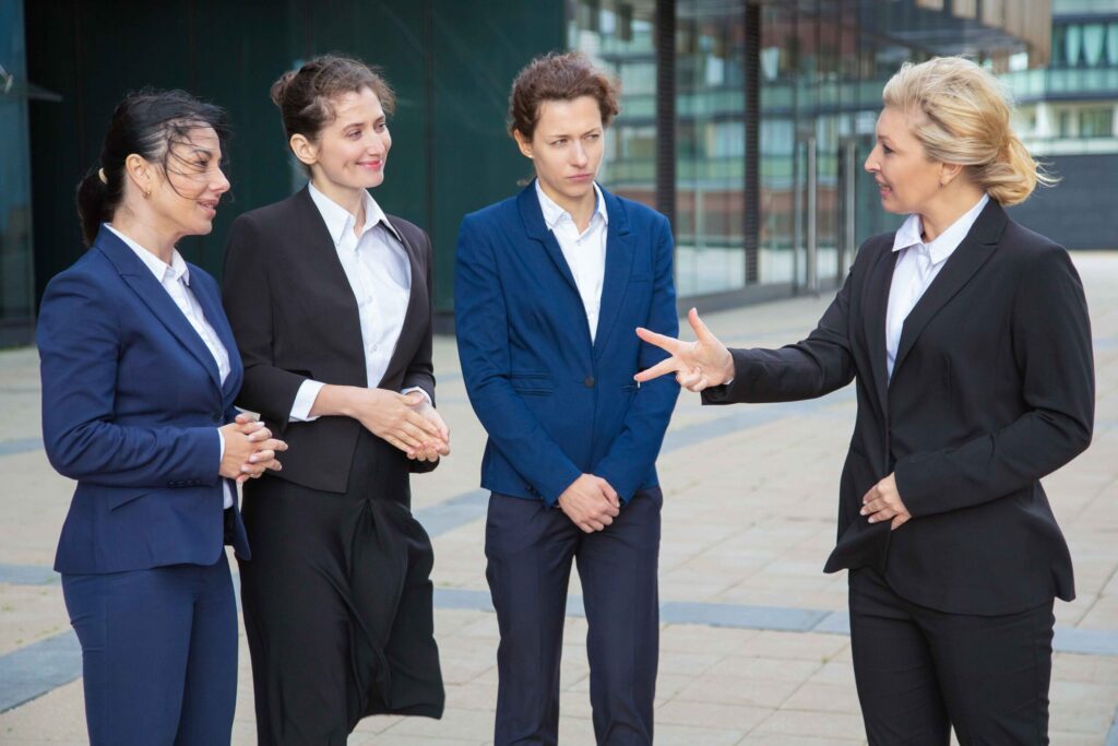 business-leader-instructing-inspiring-female-team-businesswomen-wearing-suits-meeting-talking-city-leadership-teamwork-concept