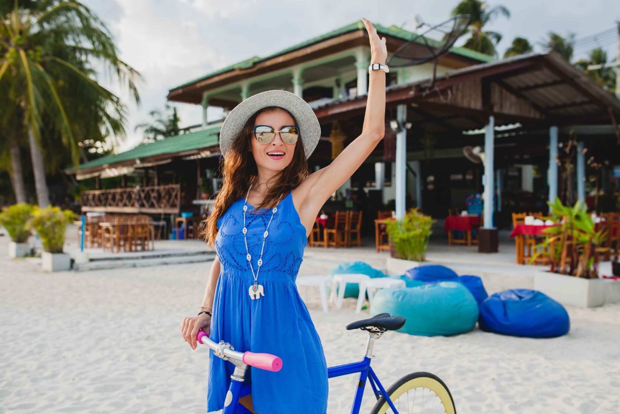 young-attractive-smiling-woman-blue-dress-walking-tropical-beach-with-bicycle-wearing-hat-sunglasses