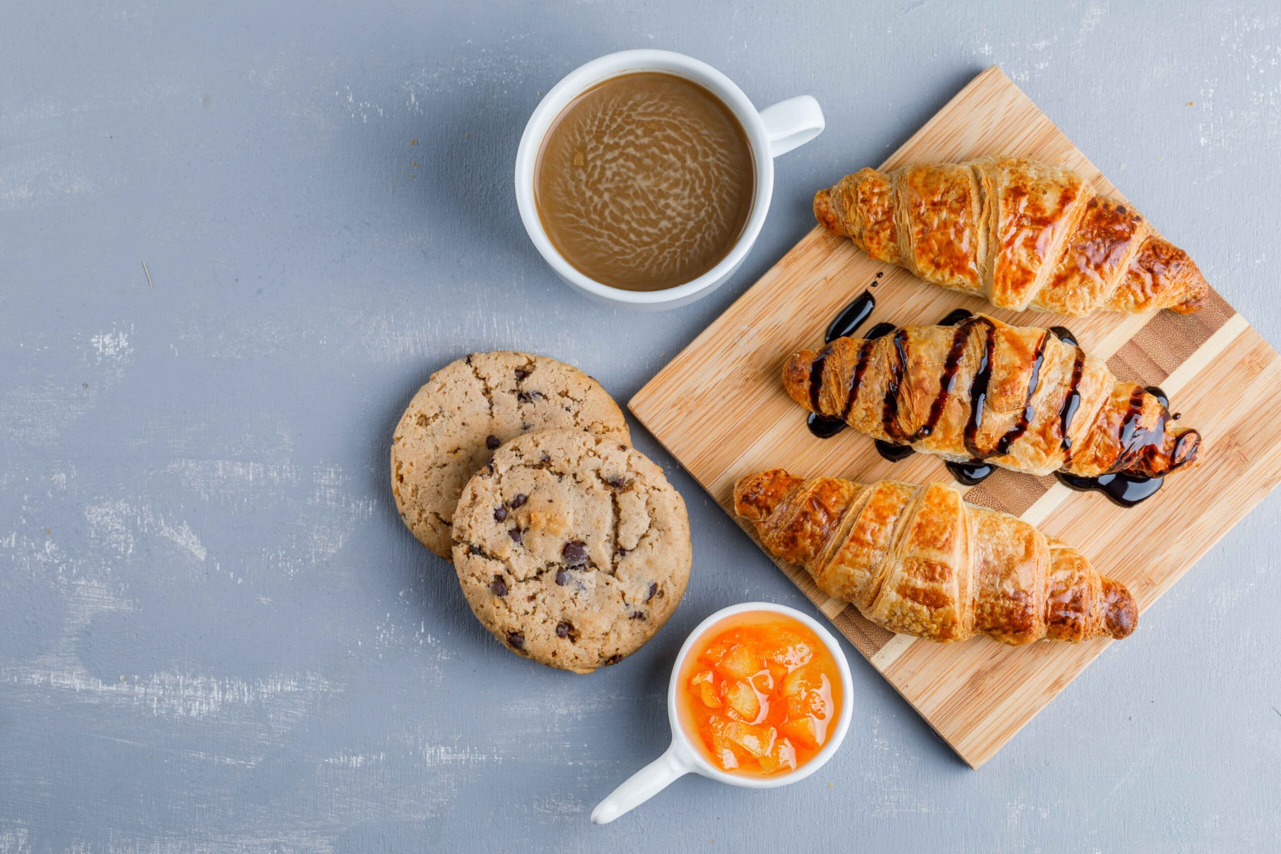 croissants-with-coffee-cookies-sauce-flat-lay-plaster-wooden-board (1)