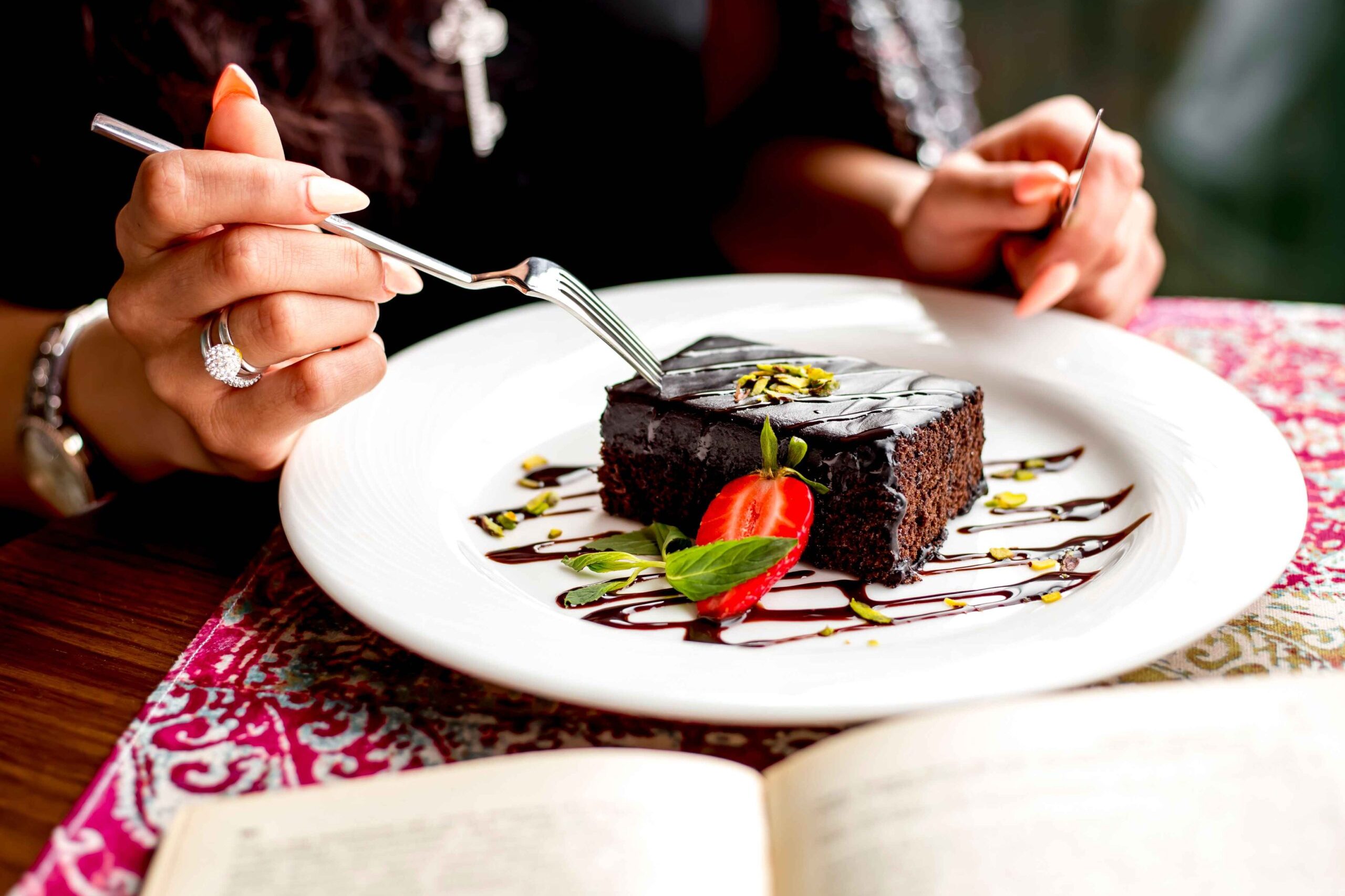 side-view-woman-eating-chocolate-cake-decorated-with-strawberry-table (1)